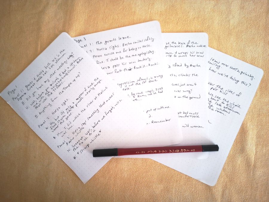 photo of handwritten script on a yellow cloth. A double-tipped brush pen lays across them all as they fan out